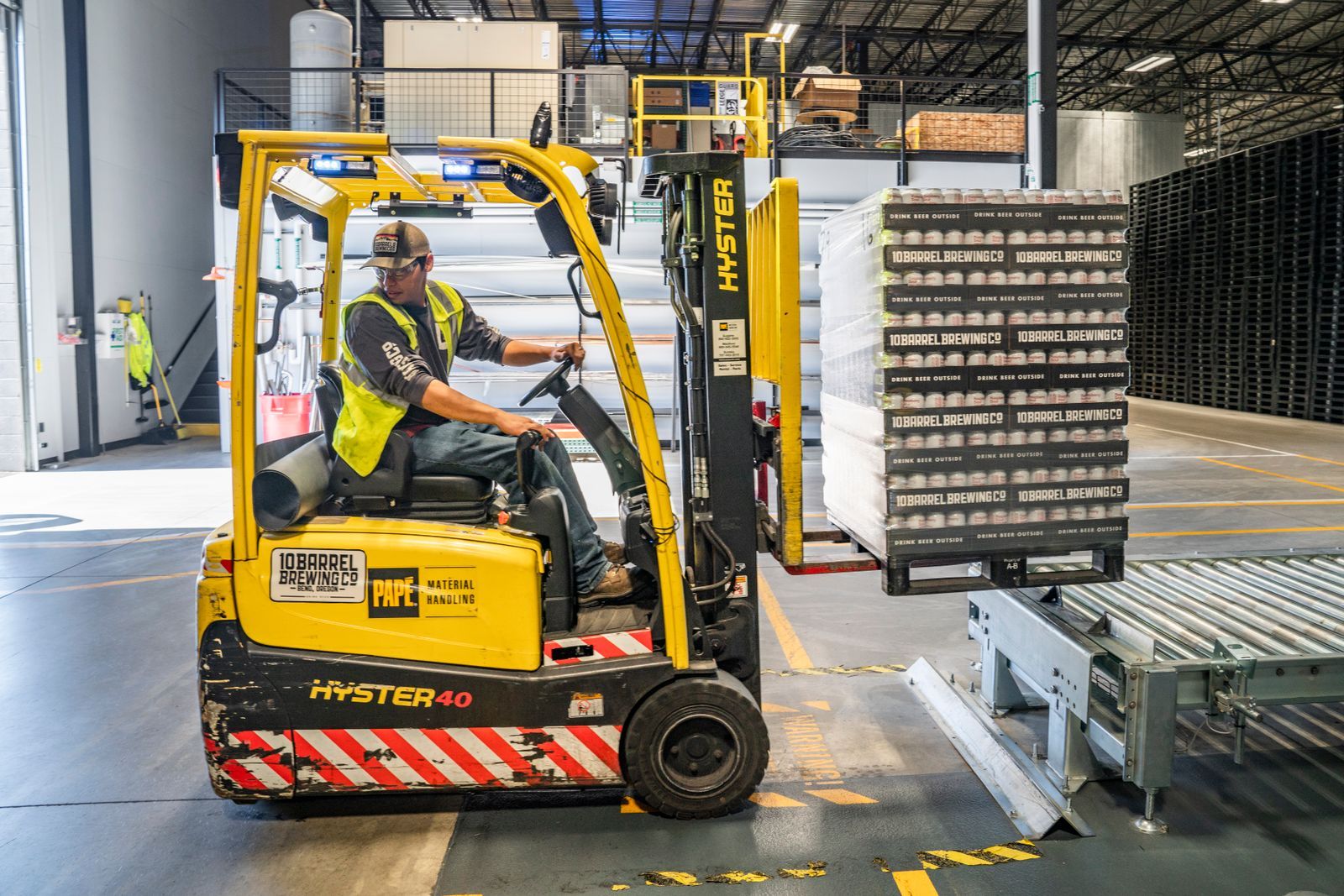 Forklift carrying a loaded pallet inside a warehouse